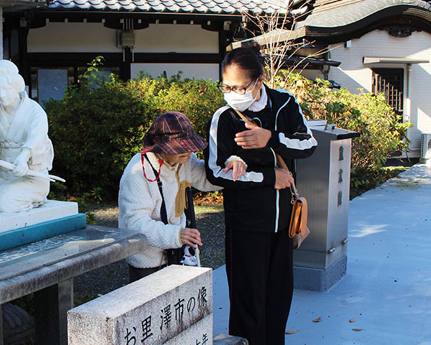 盲老人ホームのスタッフが利用者を連れて介助する様子